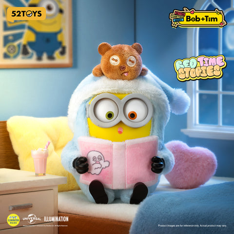 Minion Bob wearing a fuzzy blue hooded pajamas reading a pink book with Tim the bear resting on his head.