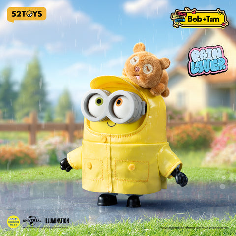 Minion Bob wearing a glossy yellow raincoat and matching hat, with Tim the bear perched on top of the hood.