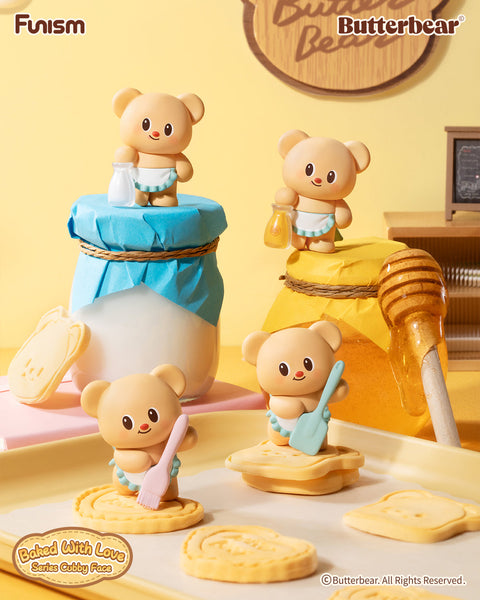 Butterbear “Baked With Love” blind box figures posed in a bright kitchen. One holds a milk bottle, another carries honey, while others wield baking tools like a spatula and pastry brush. Surrounded by cookies and jars, the bears bring cheerful, cubby charm to a baking-inspired collectible scene.