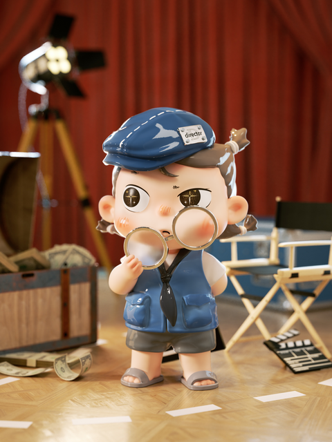 The Gold Medal Director figure stands in a staged film set, wearing a blue cap labeled “director,” vest, and shorts. Holding two large magnifying glasses, the character peers out intensely as if inspecting the scene. Behind them are vintage film props including a spotlight, director’s chair, and wooden chest filled with money, reinforcing the cinematic theme.