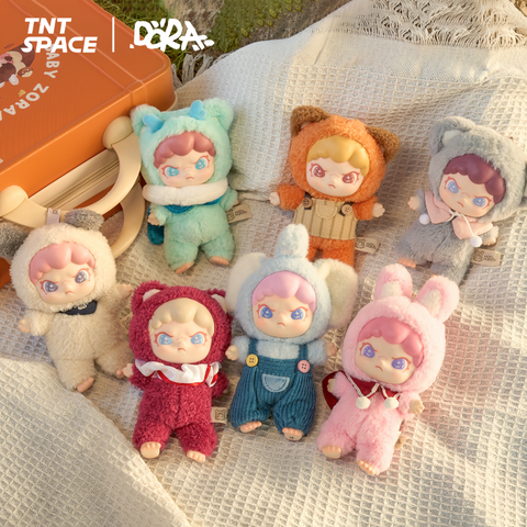 Full display of the Dora Animals Series Plush Blind Box, showing all designs including Baby Bear, Baby Elephant, Bunny, Doggy, Fox, Koala, and Dragon chaser. Figures are posed outdoors on a blanket and grassy field, highlighting their pastel animal costumes and starry-eyed expressions.