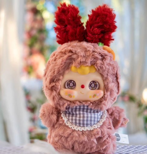 Rabbit Doubao plush in a fluffy pink suit with tall red fuzzy ears and a soft checkered bib trimmed with lace. Its big round eyes sparkle with bunny reflections, rosy cheeks brighten its face, and the playful outfit captures a sweet springtime energy in this animal school design.