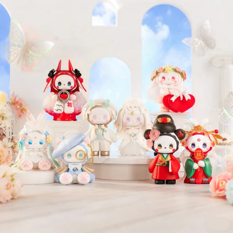 A set of intricately designed figurines from the "Emma Secret Forest: Beloved Series" is displayed in a dreamy setting. Each figure has pastel tones, elegant outfits, and detailed accessories inspired by romance, mythology, and culture. Some wear flowing dresses, floral crowns, or ornate headpieces, while others feature wings, a monocle, or traditional wedding attire. The soft background with white arches, butterflies, and flowers enhances the fairytale-like scene.