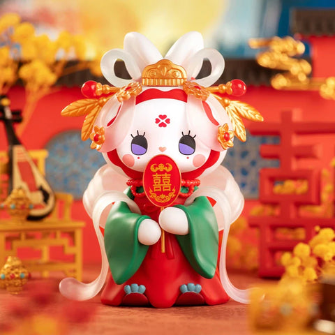 A beautifully detailed figurine from the "Emma Secret Forest: Beloved Series" is dressed in traditional Chinese wedding attire. The character wears a red and green gown with flowing translucent sleeves, golden floral headpieces, and a golden crown. It holds a red plaque with the Chinese "double happiness" symbol, symbolizing love and marriage. The vibrant background, featuring red and gold décor, intricate patterns, and festive ornaments, enhances the celebratory, culturally rich atmosphere.