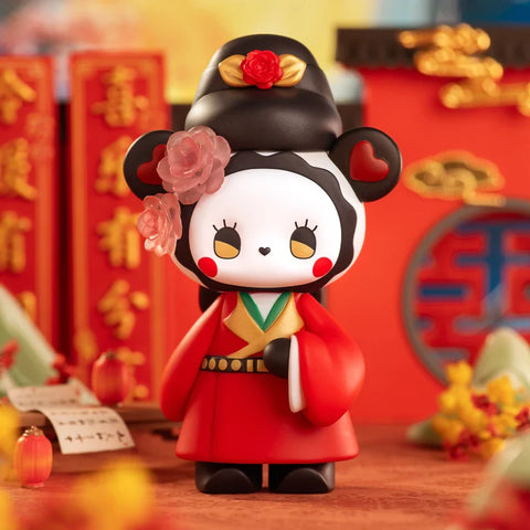 A charming figurine from the "Emma Secret Forest: Beloved Series" is dressed in traditional Chinese-inspired attire. The character has panda-like features, wearing a red and gold robe with intricate details, a black headdress adorned with roses, and heart-shaped ear markings. A translucent pink flower decorates one side of its face. The background, featuring red lanterns, golden accents, and festive scrolls, enhances the regal and culturally rich wedding-themed atmosphere.