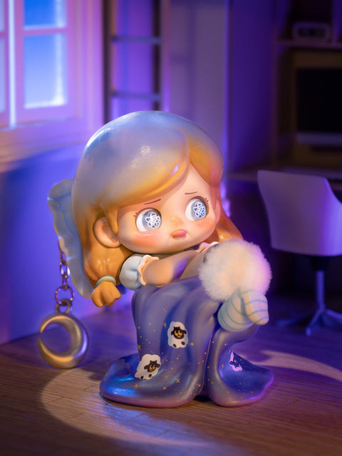 Secret chaser KO Insomnia depicts a girl in pajamas with golden hair, wide sleepless eyes patterned with clock motifs, and a blanket adorned with sheep. She sits under moonlight with a dangling crescent accessory, embodying late-night restlessness and surreal dreamlike mood in the Kokosa KO Girls lineup.