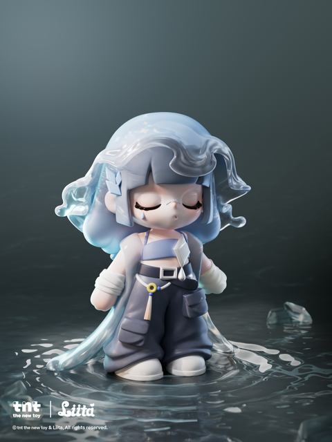 A figurine with light blue hair covered by a glossy, translucent water-like layer stands in shallow reflective water. Her eyes are closed, with a single blue teardrop marking beneath one eye. She wears dark cargo pants, a blue top, white shoes, and a long flowing cape that drapes into the water around her.