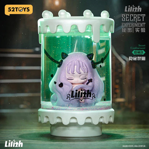 A mysterious figure from the "Lilith: Secret Experiment" blind box series is displayed inside a transparent capsule filled with glittery green liquid, labeled “Secret Confinement.” The character has pastel purple hair, closed eyes, and tiny horns, giving a peaceful yet eerie appearance. The capsule is topped with a white, dripping design, resembling a lab experiment container. The dark, industrial background adds to the gothic, sci-fi atmosphere of the secret chaser edition.