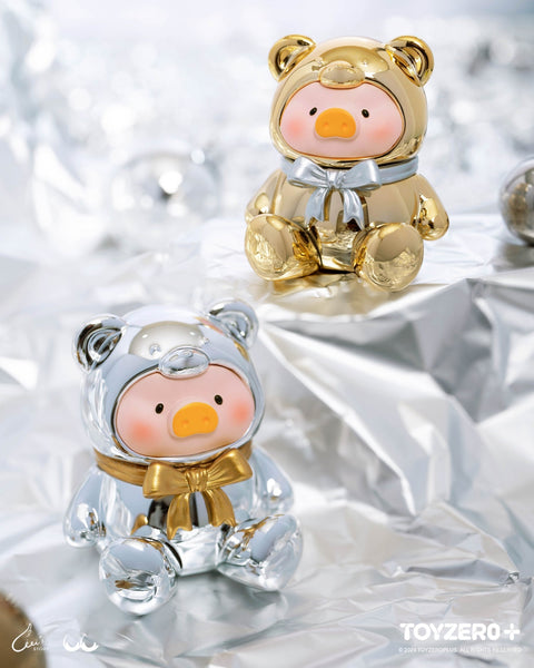 Two metallic teddy-suited piggy figures shine against a silver background. One is gold with a silver bow, the other silver with a gold bow, both reflective and glossy.