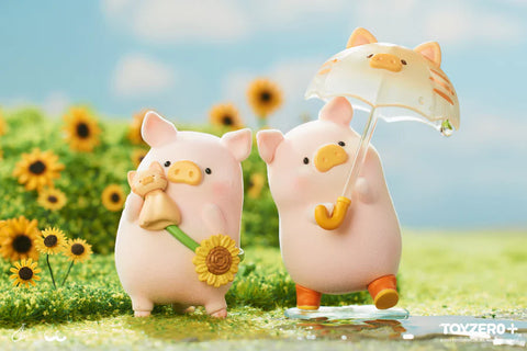 Two LuLu the Piggy figures from the Travel Series by 52TOYS and ToyZero+ enjoy contrasting weather in a bright sunflower field. One pig holds a sunflower and a small teddy bear, representing a sunny day. The other pig stands on a clear water puddle, holding a translucent umbrella with a cat design, capturing the charm of a rainy day. Their cheerful expressions and playful poses create a whimsical, heartwarming scene.