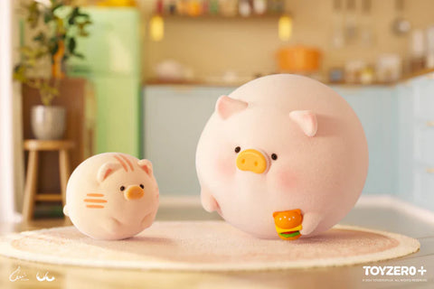 In this delightful scene from the “Lulu the Piggy: Stay With You” blind box series, a chubby piggy figurine sits adorably on a soft rug in a pastel-colored kitchen, holding a tiny burger with a happy expression. Next to it, a round, equally plump cat companion mimics its pose, both resembling cuddly plush balls. The background features kitchen shelves, light blue cabinets, and warm lighting that enhance the cozy and playful charm of this mealtime moment.