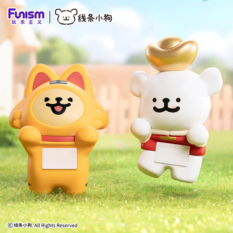 A golden pup in a lucky cat costume and a white pup wearing a large traditional golden ingot on its head.