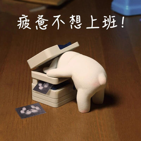 A tired bunny leans forward into a copier machine with printed paw images scattered on the desk, symbolizing workplace exhaustion and burnout.