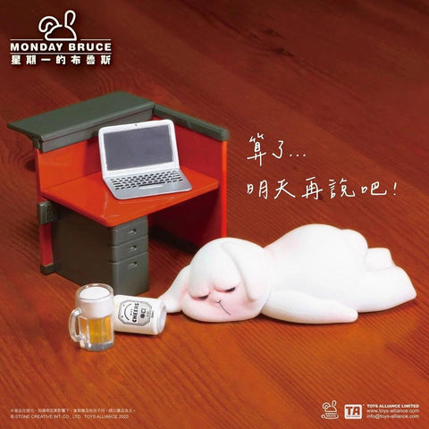 Bunny lies stretched out on the floor next to a desk with a beer mug and can. A laptop sits on the desk, while the rabbit’s expression and posture suggest giving up until tomorrow.