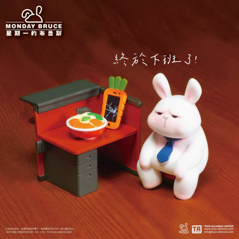 Bunny figure from Monday Bruce Series 2 sits at a red desk with a carrot phone and a bowl of food. The rabbit looks drained, reflecting exhaustion and relief that the workday is finally over.