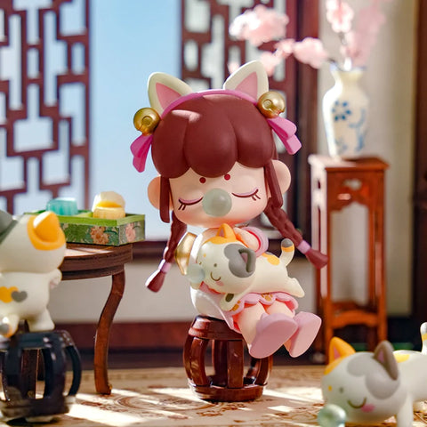 A cozy collectible figurine from the "Nanci Blooming Girl" series features a girl with braided hair, wearing cat ears and golden bells, sitting on a wooden stool. She holds a sleeping cat in her arms while blowing a bubblegum bubble, exuding a sense of warmth and contentment. More playful cats surround her, and a traditional Chinese interior with wooden furniture and delicate decorations enhances the scene. The soft lighting and serene atmosphere capture a charming moment of relaxation and companionship.