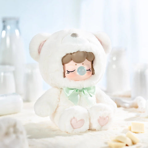 A cozy collectible figurine from the "Nanci Colorful Chocolate Cutie Bears" plush series features a character dressed in a soft, pure white bear suit with a mint green satin bow. The figure has a peaceful expression with closed eyes and a bubblegum bubble, while heart-shaped details decorate its plush paws. Set against a creamy white backdrop with milk bottles and white chocolate pieces, this scene exudes a serene, delicate, and irresistibly sweet charm.