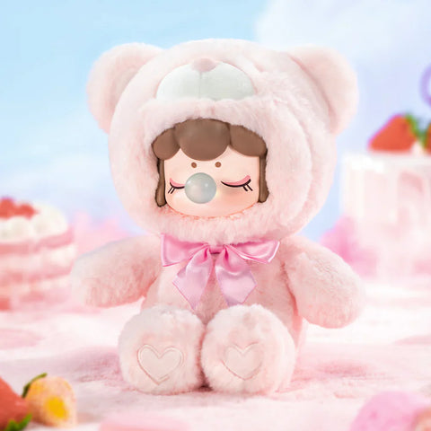 A sweet collectible figurine from the "Nanci Colorful Chocolate Cutie Bears" plush series features a character dressed in a soft, pastel pink bear suit with a matching satin bow. The figure has a peaceful expression with closed eyes and a bubblegum bubble, while heart-shaped details decorate its plush paws. Set against a dreamy backdrop with strawberry desserts and a sky-blue background, this scene exudes a soft, delicate, and irresistibly charming aesthetic.
