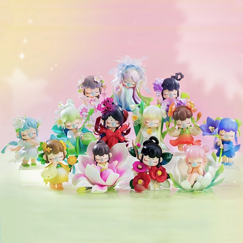 Display image for the Nanci “Flower Stories” blind box series featuring a collection of floral-themed figurines. Each character is dressed in a unique outfit inspired by a different flower, with soft pastel colors and serene, closed-eye expressions. The figurines are arranged in a tiered display with a dreamy pink background, evoking a magical garden atmosphere.