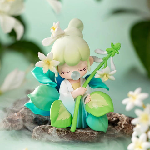 A figurine from the Nanci “Flower Stories” blind box series inspired by the plantain lily. The character has soft mint green hair styled in a top bun and wears a white and teal outfit with large leafy details. She holds a tall stem adorned with delicate white blossoms, her eyes closed as she blows a bubble. Set against a misty garden backdrop with stones and flowers, she exudes peacefulness and natural grace.
