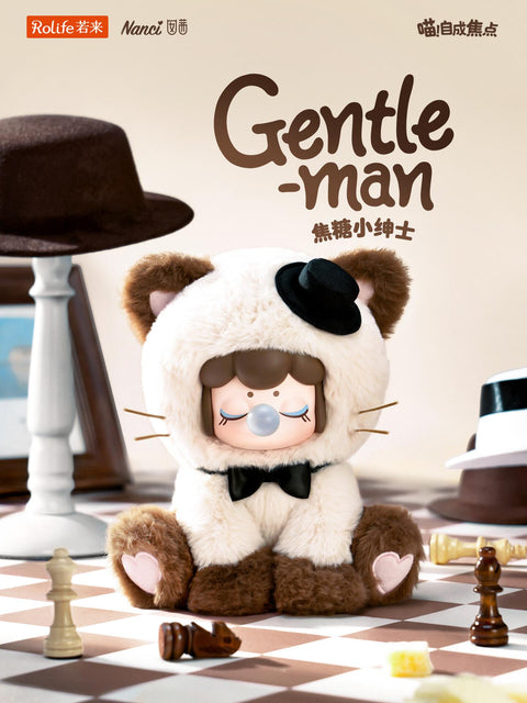 A cream and brown plush Nanci wearing a tiny black top hat and a black bow tie, sitting on a large chessboard with wooden chess pieces.