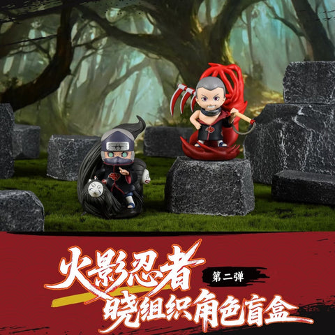 Chibi figures of Hidan and Kakuzu are displayed. Hidan wields his scythe with red energy swirling around him, posed confidently. Kakuzu appears in his stitched cloak with long black tendrils unfurled, giving a menacing, battle-ready look.