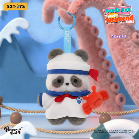 A panda plush dressed in a white sailor uniform with blue accents and a red neckerchief, holding a small plush crab.
