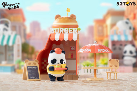 A panda figurine from the 52TOYS Panda Roll Shopping Street series stands in front of a whimsical burger shop, holding a tray with a burger and drink. The shop features a bear-shaped burger sign on top, a red-and-white striped awning, and a sandwich board menu labeled “Panda Roll.” To the side, there’s a patio setup with a red umbrella marked “Panda Roll” and a cute panda-faced chair. The background includes other panda-themed storefronts and a softly blurred cityscape, creating a playful and inviting scene
