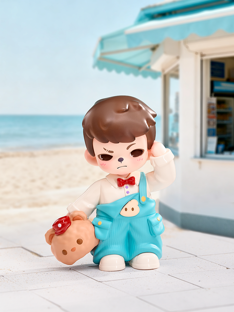 A brown-haired figure stands near a seaside shop under clear blue skies. Dressed in turquoise overalls with a bear patch and red bow tie, the figure holds a teddy-shaped cookie and blushes shyly in the bright beach light.
