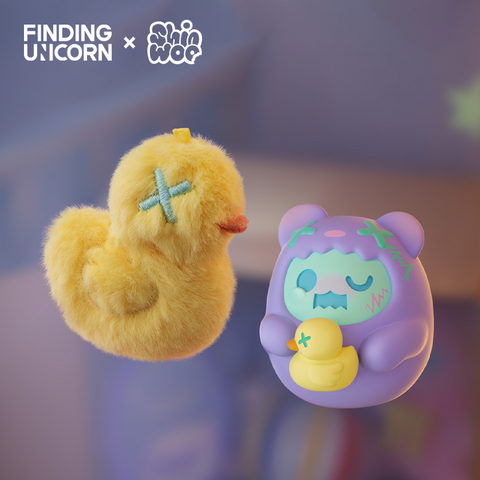 A fuzzy yellow plush duck with a stitched teal X eye floats next to a light purple vinyl bear character. The bear has green eyes, teal stitch patterns on its hood, and holds a small yellow duck with an X mark. Both figures are displayed under soft purple lighting.