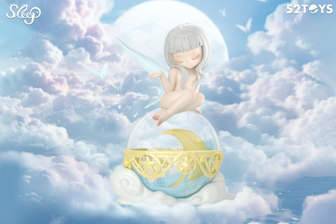 A soft, dreamy scene featuring a fairy-like figurine from 52TOYS’ Sleep series. The character has pale gray hair, translucent wings, and a peaceful expression as she sits atop a crystal-like orb with a crescent moon inside and a golden star-trimmed base. Surrounded by fluffy clouds and glowing butterflies, the sky is bathed in pastel blues and purples with a large full moon in the background, creating an ethereal, nighttime fantasy atmosphere.