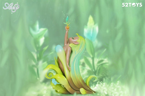 A 52Toys “Sleep: Life of Fantasies” figurine depicting a serene, elf-like character with long, green ombre hair flowing into curling leaves. Seated among soft foliage, the figure raises one arm upward, holding a translucent sprout. The lush green background and gentle glow evoke themes of growth, renewal, and the peaceful essence of nature.