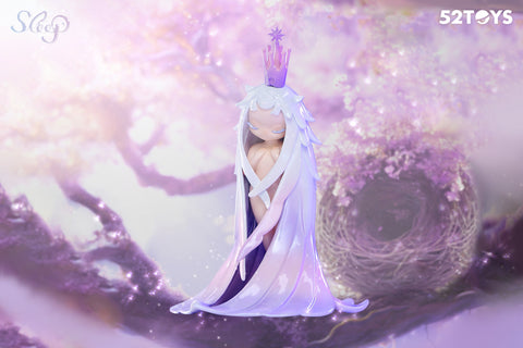 A figurine from the 52Toys “Sleep: Life of Fantasies” series titled “Time of Return” features a graceful character with eyes closed, long flowing lavender and white hair, and a crown shaped like a star-tipped scepter. The figure stands peacefully before a large nest surrounded by soft, glowing purple foliage, evoking themes of homecoming and gentle reflection.