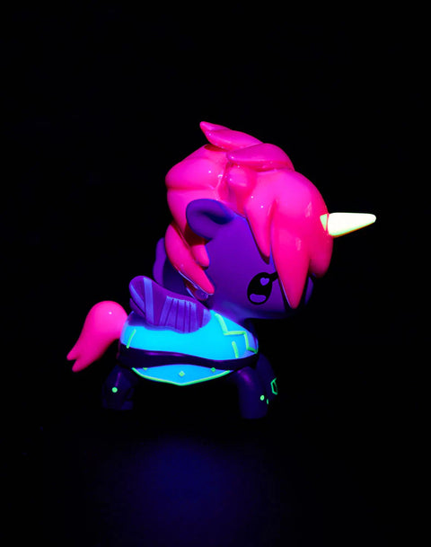 The chaser Task Force Vi glows under blacklight with intense neon highlights on her armor, especially the green striping along her legs and torso. Her horn fluoresces pale yellow, and her vivid pink hair radiates with a hot-magenta glow while the rest of her form falls into deep purple shadow.