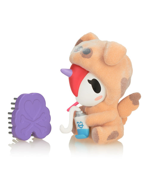 Woofy the Unicorno, featuring a tan and brown dog-themed onesie with a soft-touch finish and a purple bone-shaped brush accessory.