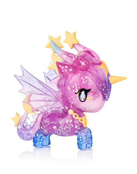 This image shows the Tokidoki Unicorno Mystical Dragon “Shooting Star Dragon,” a translucent purple and blue glittery figure decorated with star patterns. It has yellow star accents on its head and tail, translucent wings, and a gold chain collar, photographed against a white background.