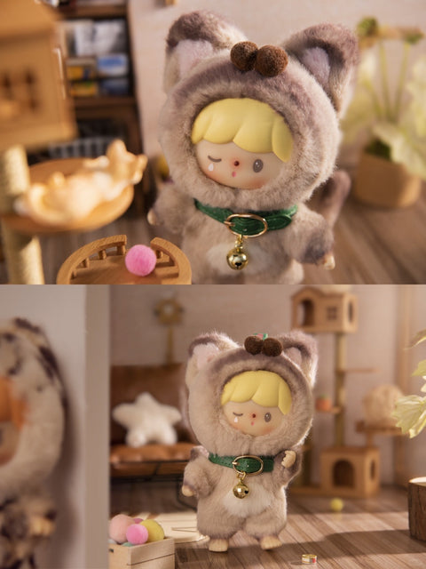 Two images of the Curious Siamese Cat plush from the Finding Unicorn x 卓大王 “My Little Cat Series” blind box. The doll has a playful expression, winking with a tiny tear detail under one eye, and wears a soft light brown and cream-colored cat suit with pointy ears and a long tail. It features a green collar with a gold bell. Set in a warm-toned miniature room with cat toys, furniture, and gentle lighting, the scene captures a cozy and whimsical cat lover’s world.