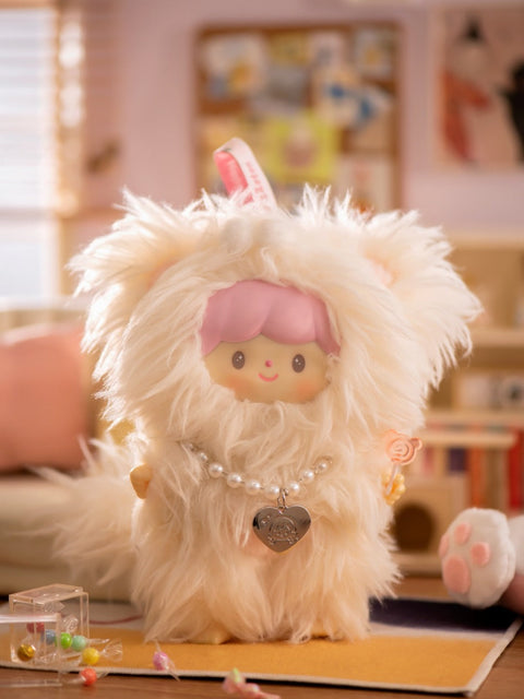 A close-up of the Tsundere Persian Cat plush from the Finding Unicorn x 卓大王 “My Little Cat Series” blind box. The doll features a soft expression, pink hair, and is dressed in an ultra-fluffy white cat costume with perky ears. It accessorizes with a pearl-beaded necklace and a silver heart pendant engraved with a cat design. A tiny lollipop is held in one hand. Set in a cozy, pastel-toned room with candy, plush décor, and soft lighting, the scene feels dreamy and sweet.