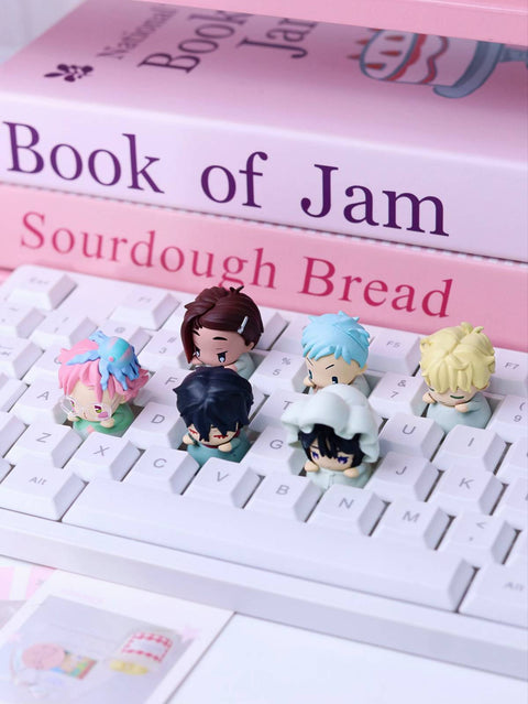 A white mechanical keyboard with the six character keycaps installed, demonstrating their functional use as decorative artisanal keycaps.