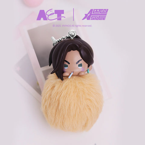 Plush pom-pom keychain representing Hyuna from Alien Stage, featuring a chibi-style head with dark hair and a confident expression resting on a warm tan fuzzy pom-pom base. Includes a silver ball chain and minimal studio backdrop with soft lighting.