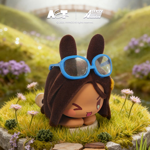 A brown-furred rabbit figure wearing blue-rimmed sunglasses and a yellow star accessory, winking while kneeling on a mossy rock surrounded by flowers.