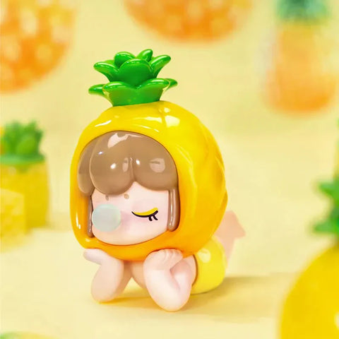 This image features an adorable collectible figurine from the Baby Nanci Fruits Series Blind Box collection. The character has a peaceful expression with closed eyes and hands resting on its cheeks in a relaxed pose. It wears a glossy, bright yellow pineapple-inspired headpiece with a textured surface and a vibrant green leafy crown on top. The figure’s short brown hair peeks out from the fruit-themed hood, adding a charming touch. The background is a soft pastel yellow.