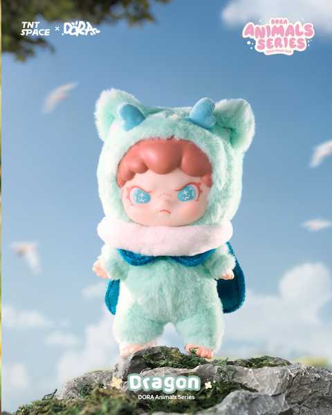 The secret chaser plush doll wears a mint-green dragon costume with tiny blue horns, fuzzy hood, and soft wings. Its pale skin and light auburn hair frame starry turquoise eyes, creating a magical aura. The figure stands barefoot atop a mossy rock under an open sky, adding a fantasy-like mythical presence.