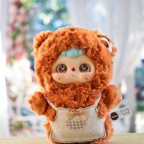 A fluffy Doubao plush dressed as a bear, with an orange-brown fuzzy suit and checkered apron featuring a bow and pocket, standing indoors with soft light. Its big round eyes sparkle with bear-themed pupils, rosy cheeks, and a red nose, capturing a gentle woodland-inspired charm.