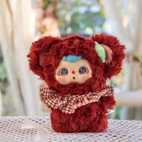 Koala Doubao plush in a deep reddish-brown fluffy suit with rounded ears and checkered bow bib. Its round face, blue hair tuft, and sparkling koala-reflected eyes create a cozy, sleepy charm, evoking cuddly forest vibes in this animal school-inspired design.