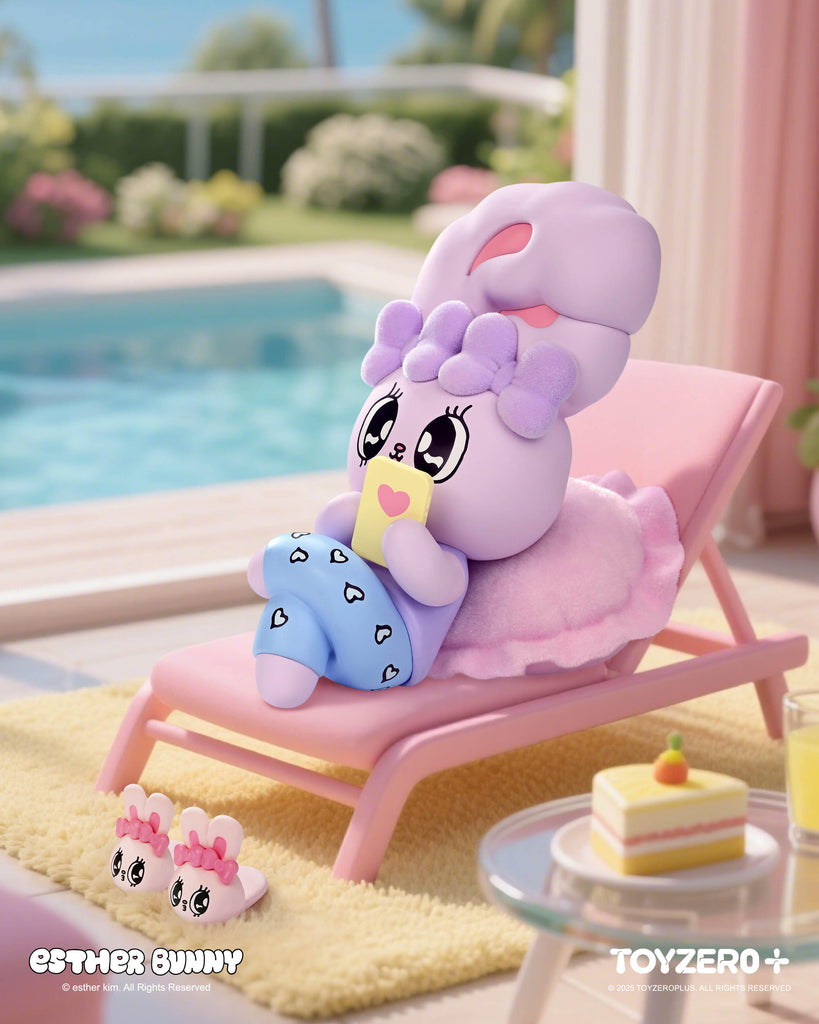 A lavender Esther Bunny figurine with a fluffy purple bow lounges on a pink chair by the pool. Dressed in blue heart-patterned pants, it relaxes with a yellow drink carton featuring a heart design. Bunny slippers rest nearby, while a slice of cake and juice sit on a glass side table.