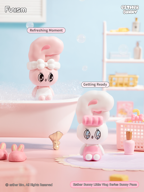 A bathroom-themed setup where one bunny lounges by a bubble-filled bathtub and another prepares in front of pink toiletries. The soft pastel colors emphasize a refreshing and self-care morning routine.
