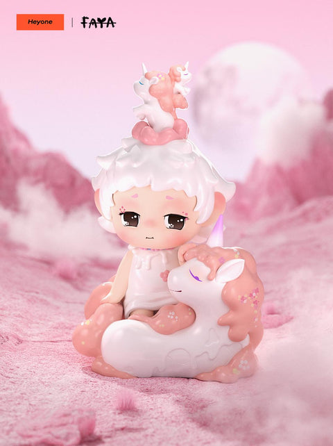 Dreaming Unicorn figure rests with a pink unicorn, with another atop its head, set in soft pink clouds, symbolizing innocence and fantasy.