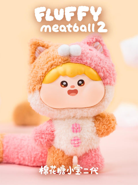 Plush doll in a fluffy calico cat costume with orange and pink details, big cat ears, and a long striped tail. The sweet expression, rounded cheeks, and cozy texture highlight the playful charm of the collectible.