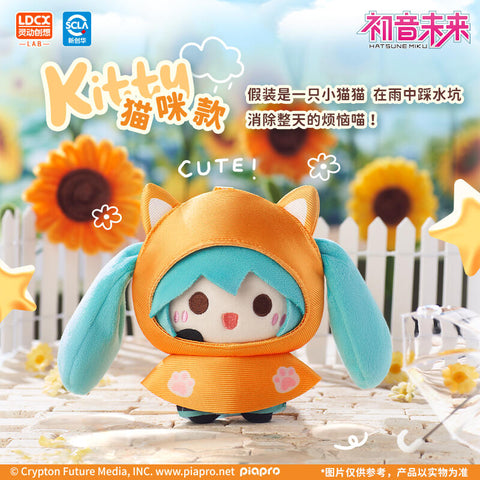 Hatsune Miku plush dressed in a kitty-style raincoat, with an orange hood featuring cat ears and paw-print accents. Her turquoise twin tails frame her happy expression, creating a playful feline look. Displayed in a sunflower field with doodle stars and clouds, the setting adds bright, cheerful energy.